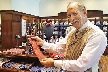 Associate Robert Rosenthal shows off a tie bearing the timeless Brooks Brothers company logo at the store at Bilmore Fashion Park. (Photo by Josh Coddington/Greater Phoenix Chamber of Commerce)